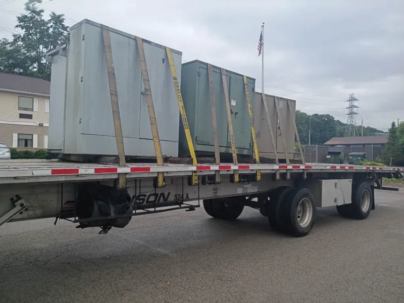 Wrapped switchgear sections staged for freight