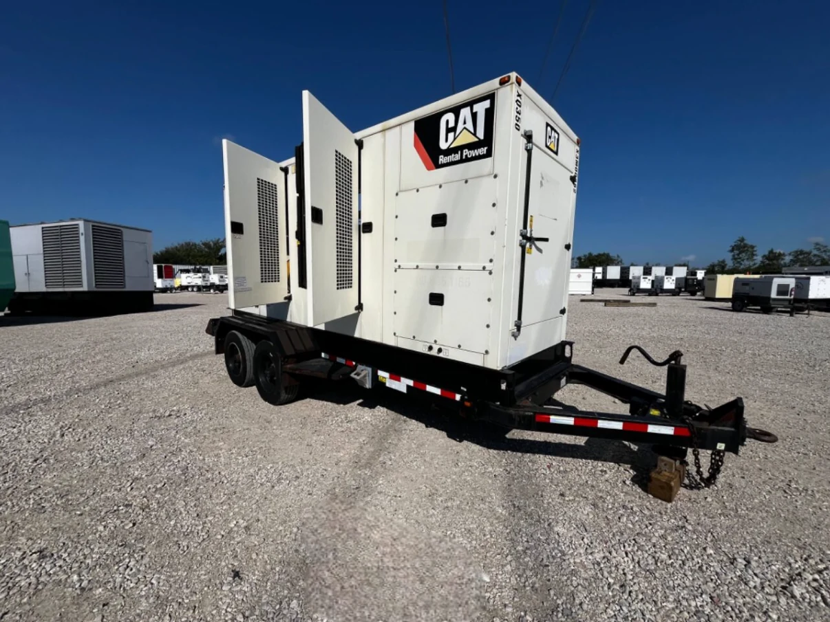 White CAT mobile generator on a dual-axle trailer with access doors open.
