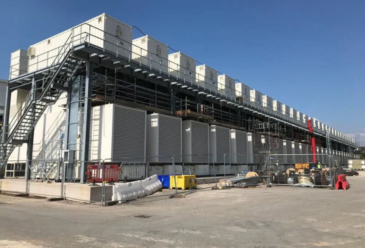 Large modular industrial power facility with cooling units and access platforms.