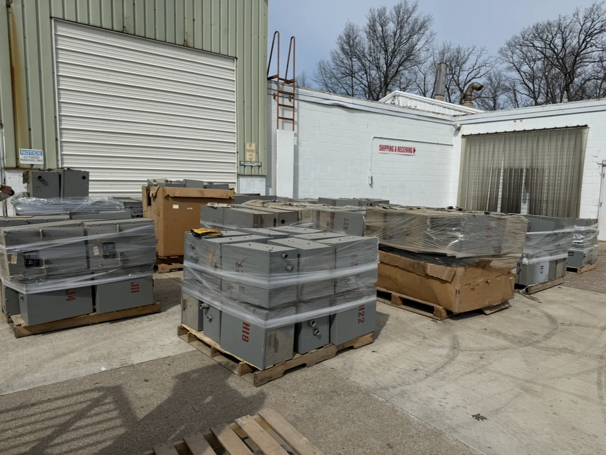 Shrink-wrapped electrical equipment staged outdoors for shipment.