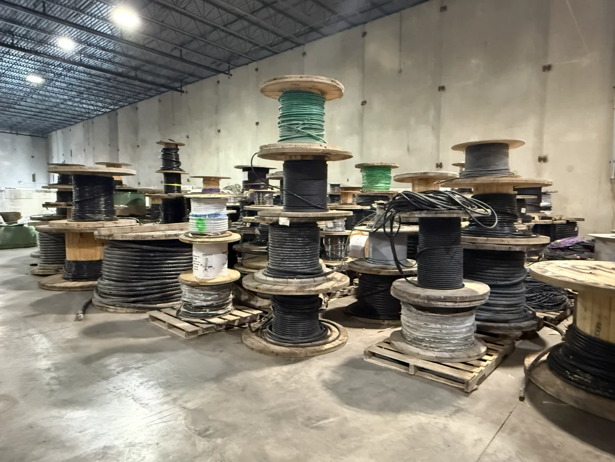 Industrial electrical cable spools stacked in a warehouse.
