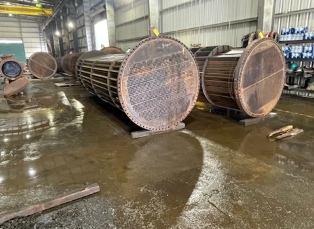 Industrial heat exchanger tube bundles on a factory floor.