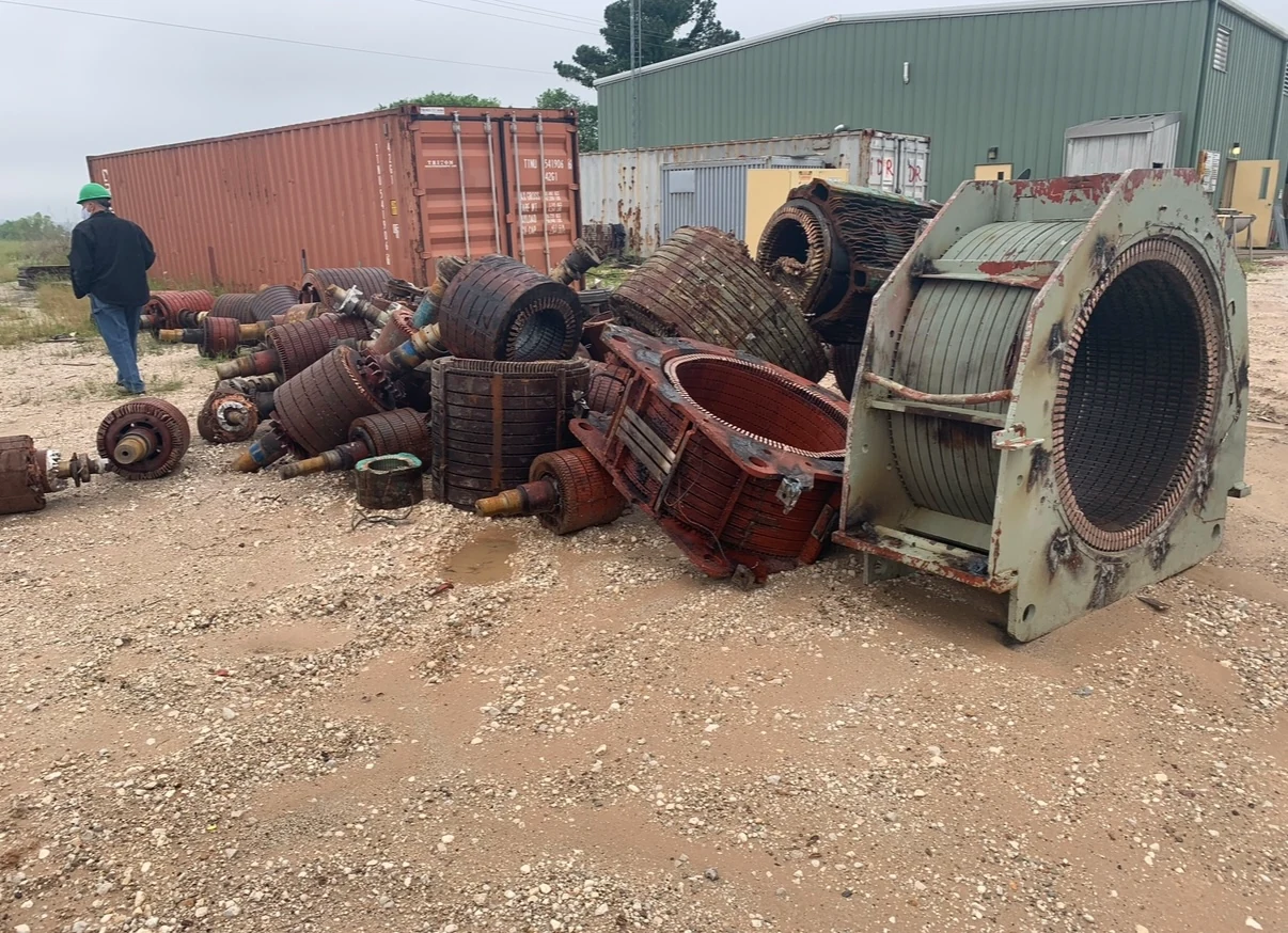 Recovered electric motor and generator components staged outdoors.