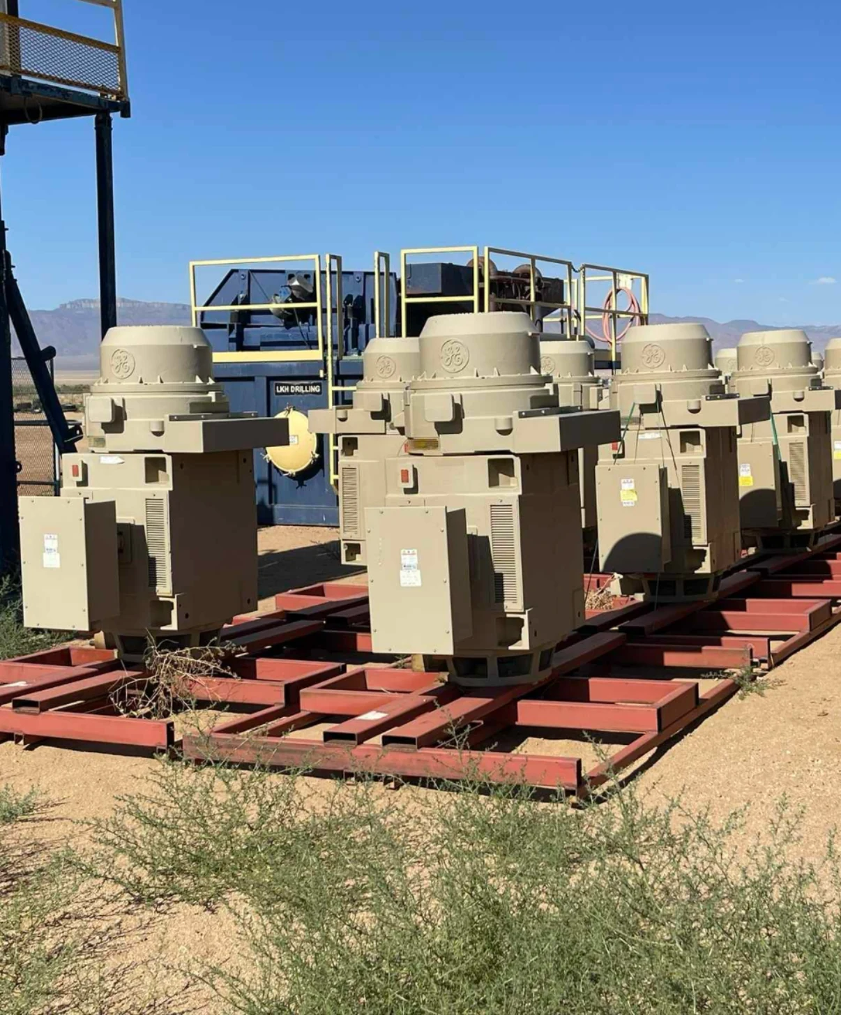 Industrial generators or motors mounted on red steel skids.