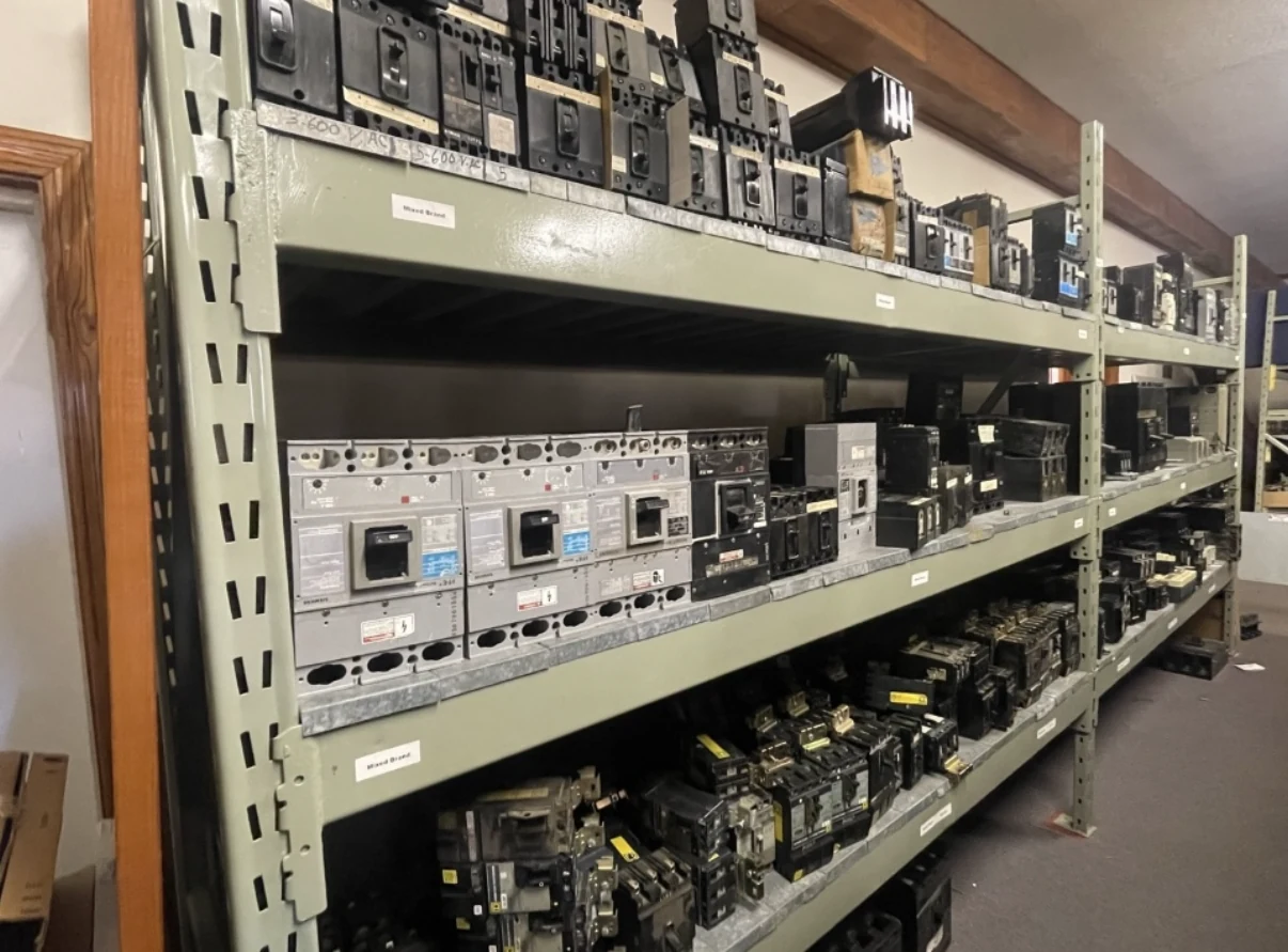 Circuit breakers organized on industrial storage racks.